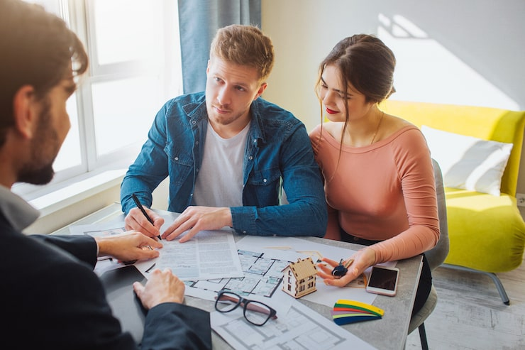 a young couple reviewing and signing their estate planning documents with a financial advisor in El Paso Texas